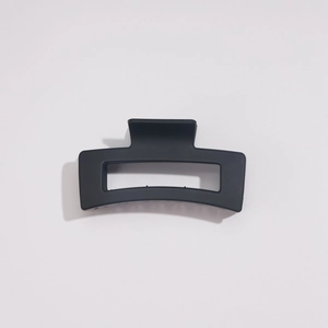 Gros plan sur la pince à cheveux rectangulaire noire mate avec détails de ressort métallique