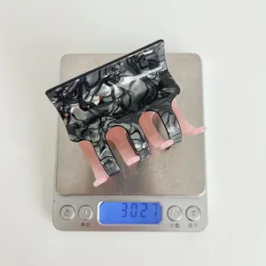 Detail shot showing a 30.27g weight measurement of the acetate square hair claw clip