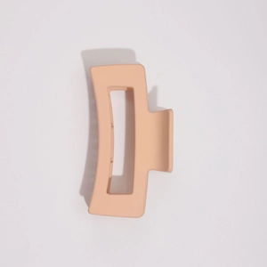 Détail d'une grande pince à cheveux mate pêche avec découpe rectangulaire et ressort