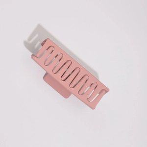 Détail de la grande pince à cheveux rose mat avec un cadre rectangulaire évidé
