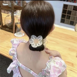 Elegant translucent white camellia hair claw clip holding a low bun on female model