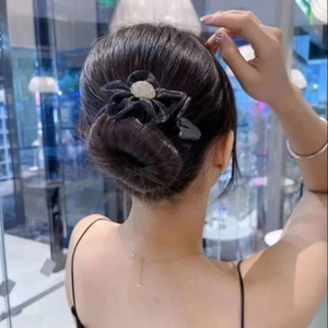 Detail of elegant black organza camellia hair claw clip with rhinestones on model