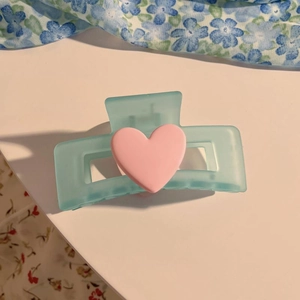 Detail einer matten hellblauen Schmetterlings Haarklammer mit rosa Herzverzierung