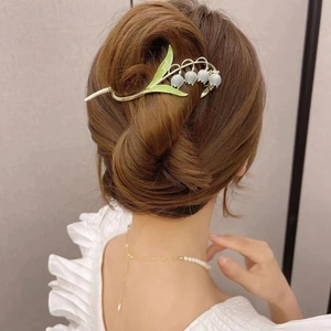 Detailopname van de elegante lelietje-van-dalen haarklem in een frans opgestoken kapsel