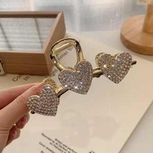 Detailansicht der Haarspange mit drei Herzen, Strasssteinen und goldener Metallbasis