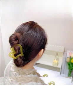Detail of yellow heart-shaped hair claw clip on semi-tied hair for young women