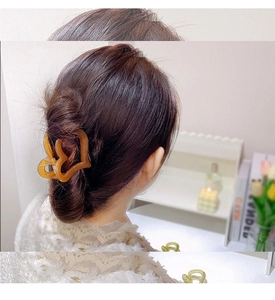 Detail shot of a transparent amber heart hair claw clip styled on back of head