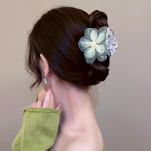 Elegant camellia hair claw with green tulle petals and pearl center for women's updos