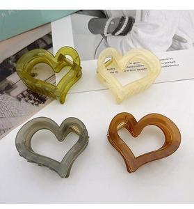 Detail showing four translucent heart-shaped hair claws in various elegant colors
