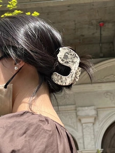 Detailaufnahme einer großen Haarklammer aus Acetat mit Marmormuster für das Haarstyling