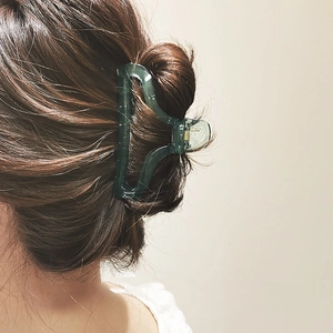 Minimalist dark green translucent acrylic hair claw clip for elegant bun hairstyle