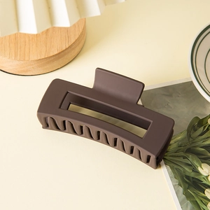 Detail view of large dark brown matte hair claw clip with rectangular hollow design