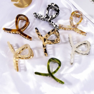 Set of 7 acetate hair claw clips in tortoise and marble patterns on silk background