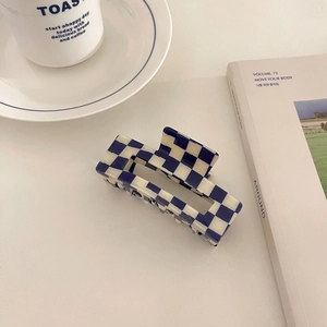 Detail showing the blue and white checkerboard pattern on the rectangular hair claw clip