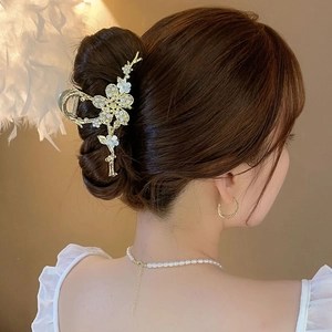 Eleganter Haarklammer aus Goldlegierung mit weißen Blumen, Perlen und Strass am Modell