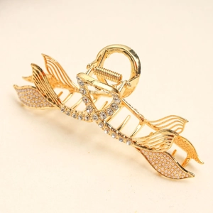 Detail of golden mermaid tail hair claw with elegant pearls and sparkling rhinestones