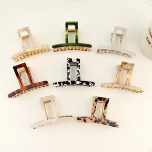 Detailed macro view of eight assorted acetate hair claws with leopard and marble patterns