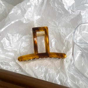Close-up of tortoise shell pattern acetate hair claw clip with golden metal spring