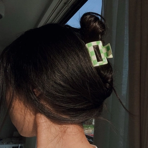 Green and white checkered hair claw clip styled on hair in natural light close-up