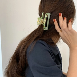 Detail showing marble green acetate claw clip securing hair on back of model's head