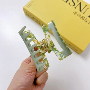 Green and yellow marbled acetate hair claw clip with cutout square design and metal spring