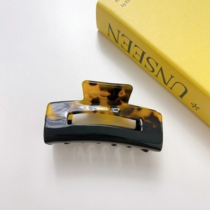 Close-up of square acetate hair claw with dual-tone black and tortoise shell finish