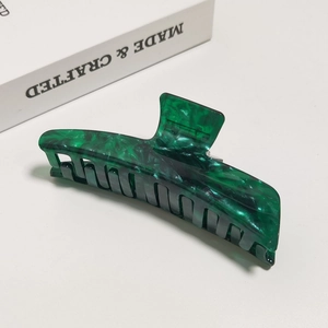 Detailed view of large dark green marble acetate shark hair claw clip for women