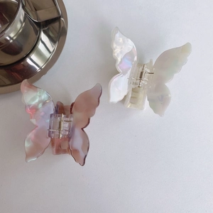 Detailed macro view of pearlescent butterfly hair claws with elegant metal spring finish