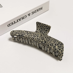 Macro detail of high-quality acetate shark hair claw featuring black and white floral pattern