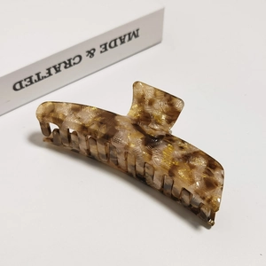 Detailed view of the tortoiseshell cellulose acetate hair claw with woven texture