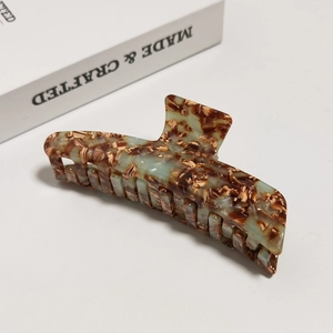Close-up of acetic acid hair claw clip with vintage marble texture and polished finish
