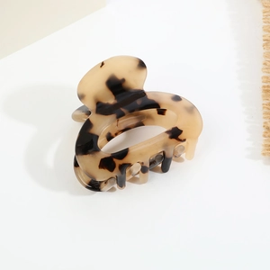 Dettaglio del fermaglio per capelli in acetato con motivo tartarugato color ambra