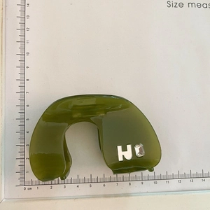 Dark green acetate hair claw clip with crystal H letter ornament shown on measurement board