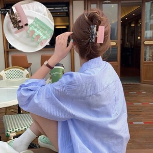 Détail de grandes pinces à cheveux en acétate rose, marbre et motif à damier vert