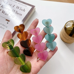 Lot de quatre barrettes à cheveux coeur en acétate coloré vert, ambre, rose et bleu