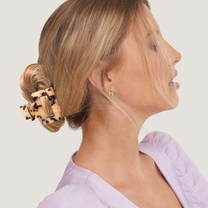 Tortoiseshell acetate rectangular hair claw clip shown on a model in a side view