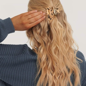 Classic tortoiseshell acetate hair claw clip styled on wavy blonde hair for daily wear