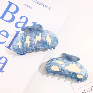 Detailed macro view of acetate cloud and lightning hair claws with blue marble texture