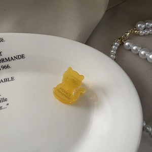 Gros plan d'une pince à cheveux jaune en forme de chat avec texte France Handmade sur plateau
