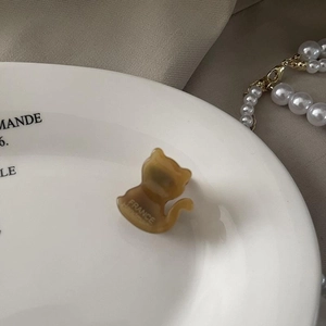Pince à cheveux chat en acétate faite main sur une assiette vintage blanche