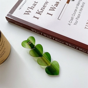 Détail de la barrette en acétate vert en forme de cœur avec lettrage doré Barrette La France