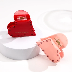 Nahaufnahme der roten und rosa Herz-Haarklammern mit glitzernden Strasssteinen und Text