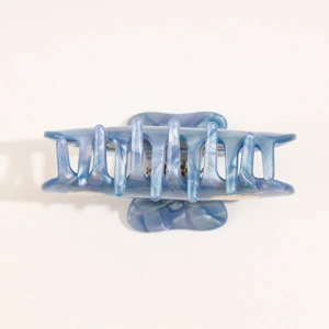Detail view of large blue marble acetate hair claw clip with strong metal spring