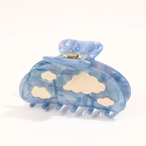 Detail of blue acetate hair claw clip featuring 3D white clouds and metallic spring hinge