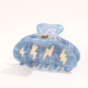 Detail of blue marble acetate hair claw clip featuring white lightning bolt patterns