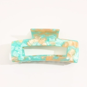 Macro view of a rectangular marble acetate hair claw clip with blue and beige texture