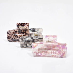 Three acetate hair claws in tortoiseshell, marble, and purple stone patterns set