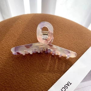 Detailed macro view of large acetate hair claw clip with pearlescent marble texture