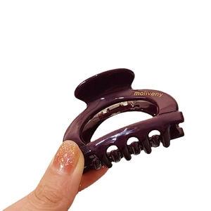 Minimalist deep purple acetate hair claw clip with golden lettering on white background