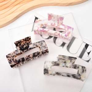 Three large rectangle acetate hair claws in marble, tortoiseshell, and ink patterns
